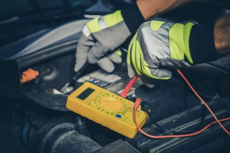 Technician testing a car battery with a digital multimeter