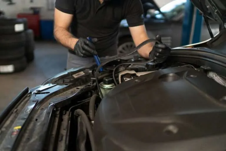 Mechanic inspecting the accessory drive belt in an engine bay