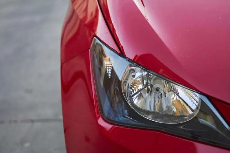 Headlight assembly on the front of a red car